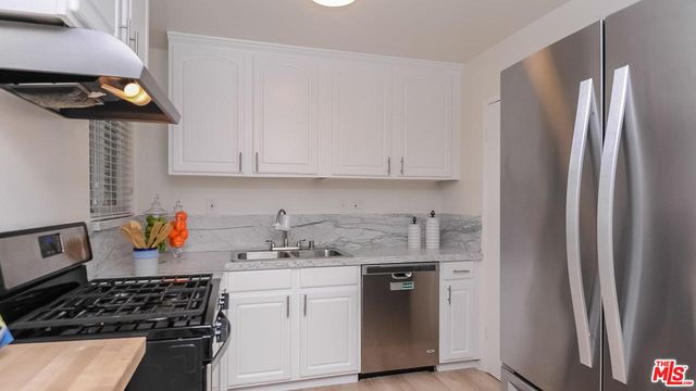 a kitchen with stainless steel appliances a stove a refrigerator and cabinets