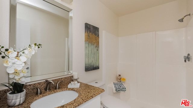 a bathroom with a granite countertop sink and a mirror