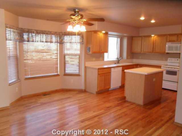 12336 Snaffle Bit Road Peyton, CO 80831 - Photo 4 of 8 The dining area is between the kitchen and the family room and has a walk-out to the backyard.