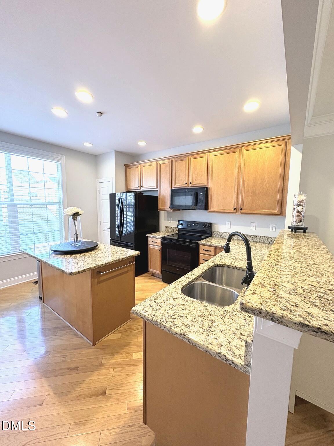 9211 Calabria Drive, Unit 117 Raleigh, NC 27617 - Photo 5 of 19 a kitchen with stainless steel appliances granite countertop a sink stove and refrigerator