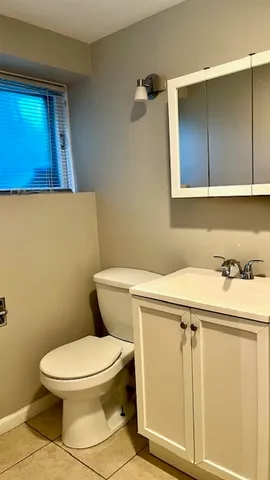 a bathroom with a toilet a sink and mirror