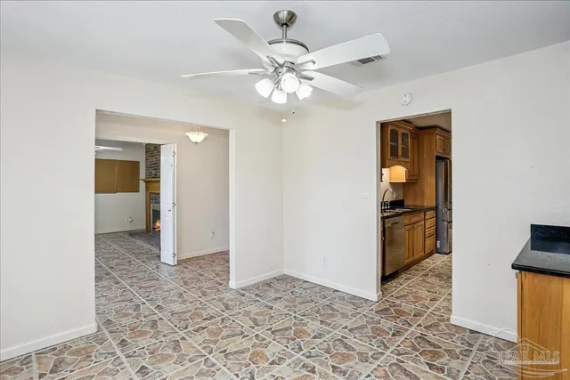 a view of an empty room with window and fire place
