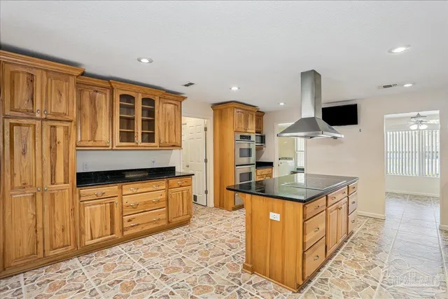 a close view of kitchen island with granite countertop cabinets and sink