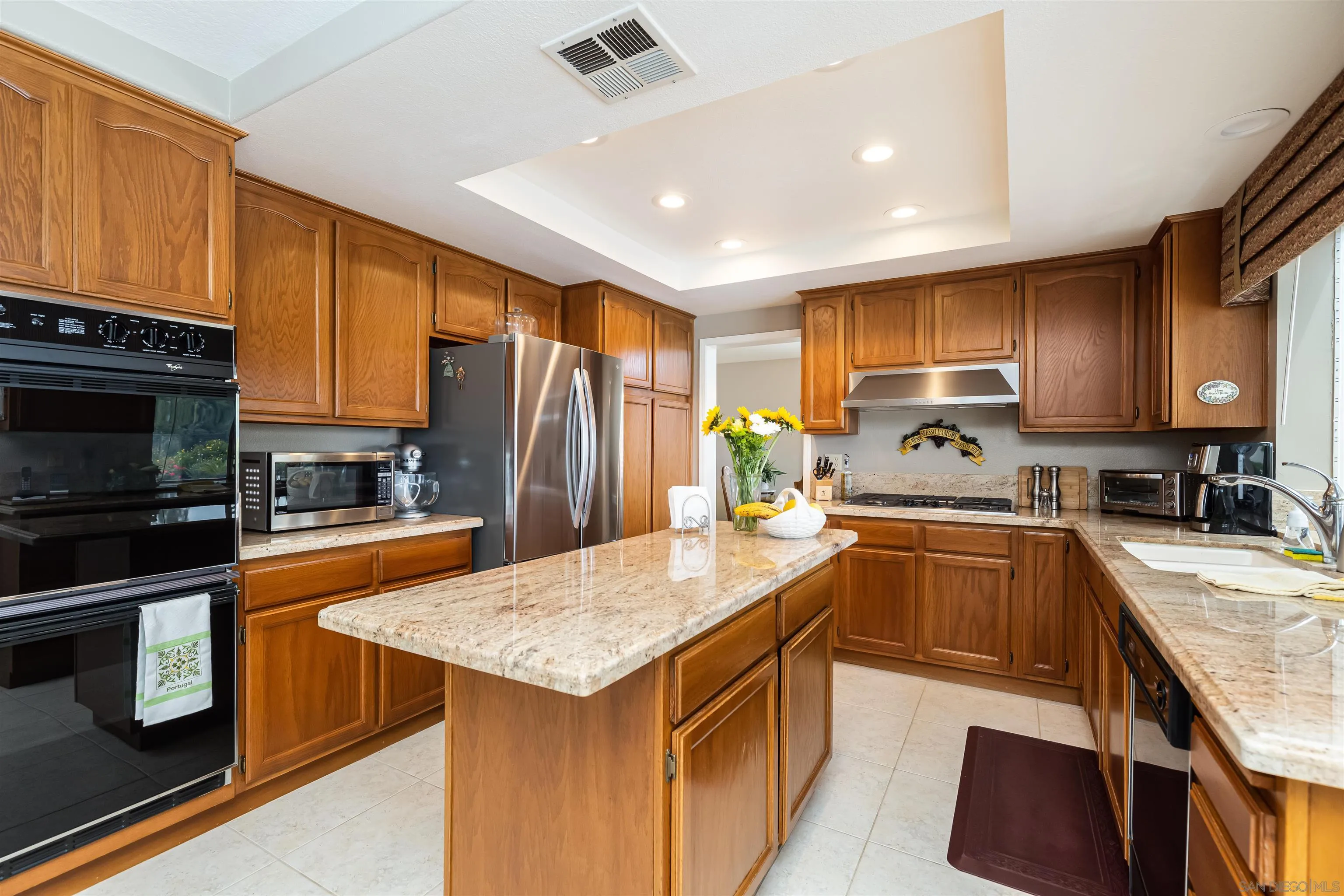 41411 Rue Jadot Temecula, CA 92591 - Photo 8 of 54 a kitchen with granite countertop a sink stove and refrigerator