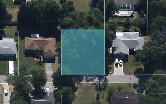 an aerial view of a house with swimming pool and outdoor seating