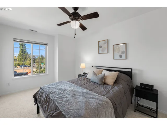 a bedroom with a bed and a painting on the wall