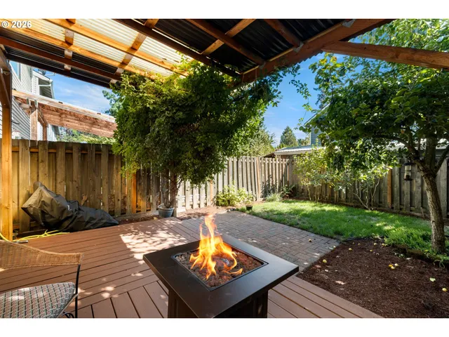 a view of a backyard with table and chairs with wooden floor and fence