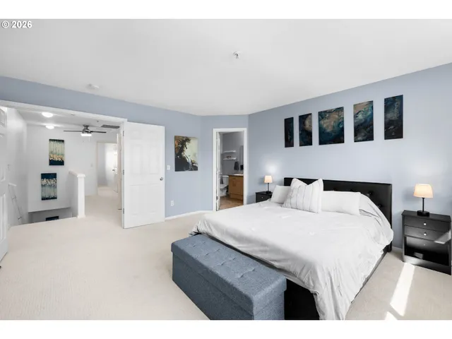 a spacious bedroom with a bed a mirror and lamp