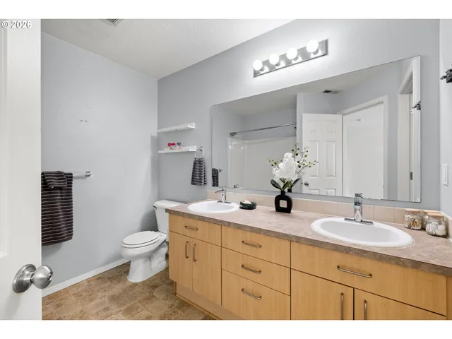 a bathroom with a double vanity sink mirror and toilet