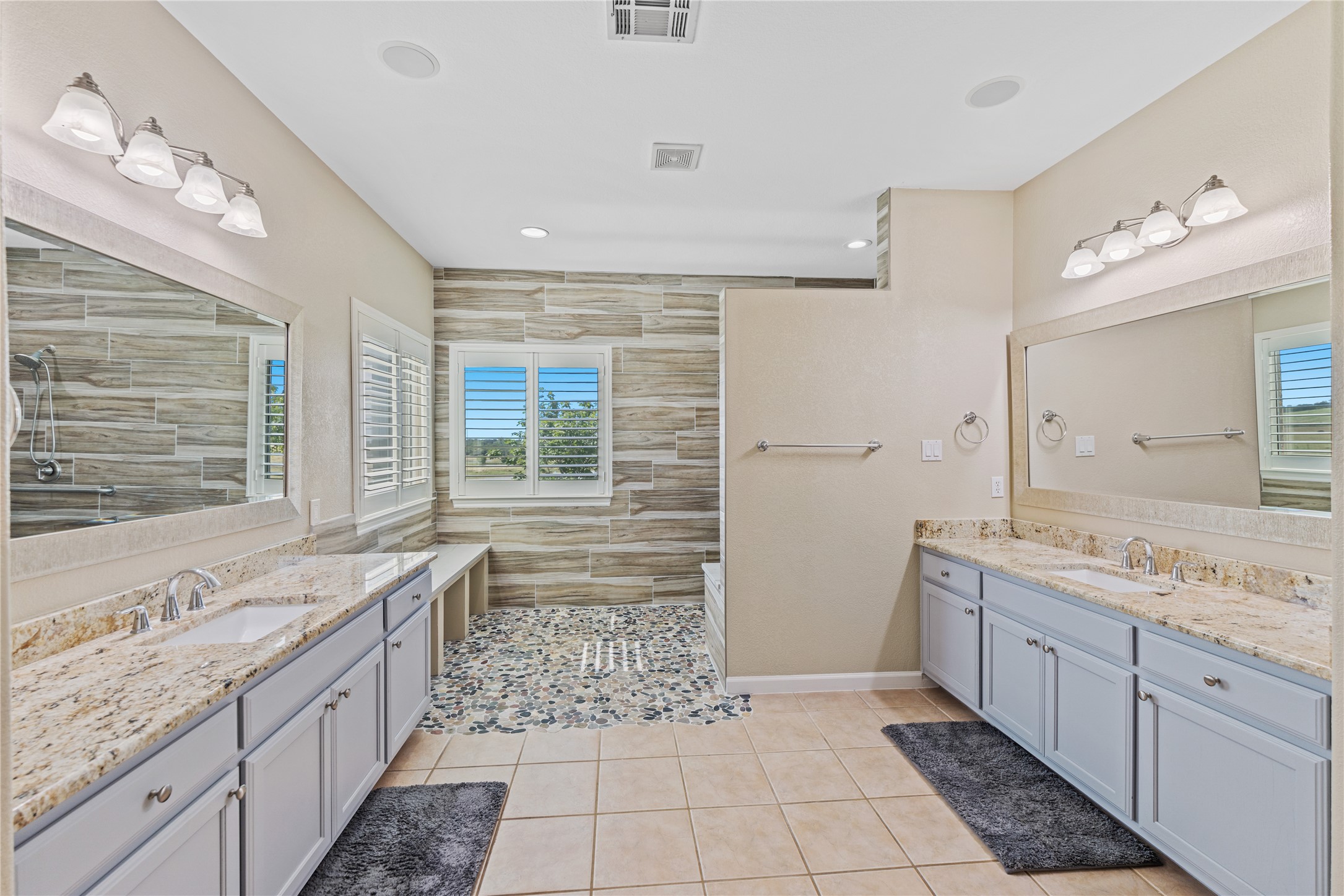 20145 Janak Road Coupland, TX 78615 - Photo 16 of 40 Granite counters and dual vanities create a spacious and elegant primary bathroom retreat.