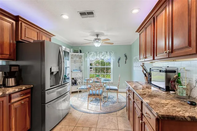 a kitchen with stainless steel appliances granite countertop a dining table and chairs with wooden floor