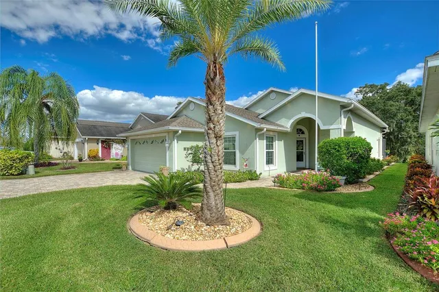 a backyard of a house with table and chairs plants and large tree