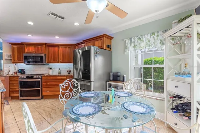 a kitchen with stainless steel appliances granite countertop a stove a sink dishwasher a dining table and chairs with wooden floor