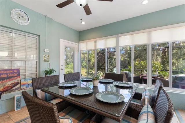a dining room with furniture large windows and a chandelier