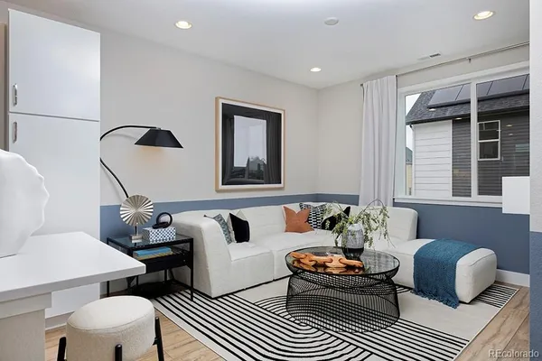 a bedroom with a bed and dresser with wooden floor