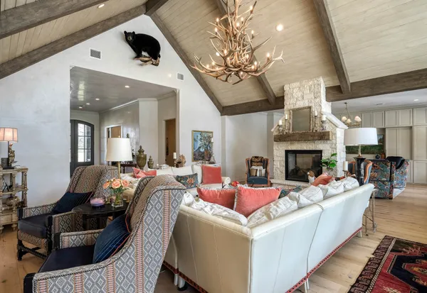 a living room with furniture a chandelier and a fireplace