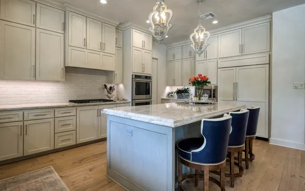 a kitchen with granite countertop a table chairs stove and cabinets