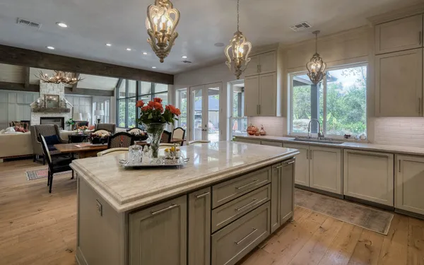 a kitchen with kitchen island granite countertop a stove and a sink