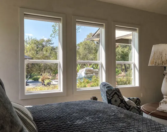 a bed sitting in a bedroom next to a window