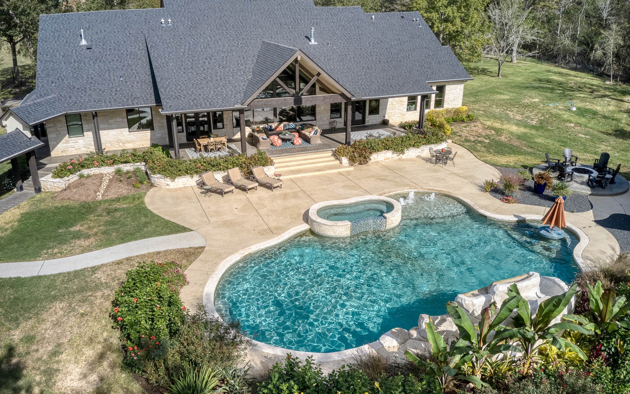 22474 Kmiec Road Hempstead, TX 77445 - Photo 32 of 50 A backyard oasis includes salt water pool with waterfall and slide, hot tub, in- pool table with umbrella, gas fire pit and cabana.