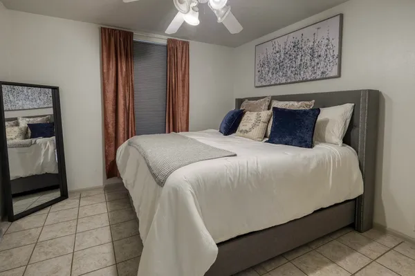 a large bed sitting in a bedroom and a chandelier