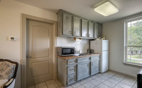 a kitchen with white cabinets and white appliances