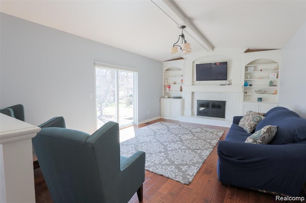 651 Kentucky Drive Rochester, MI 48307 - Photo 14 of 35 Built in Shelving flank the natural fireplace in the handsome Family room with wood flooring and door wall to patio.