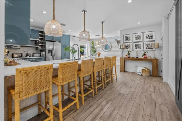 a kitchen with stainless steel appliances kitchen island granite countertop a sink cabinets and wooden floor