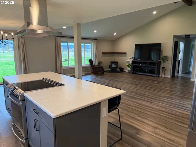 a kitchen with stainless steel appliances wooden floor dining table and chairs