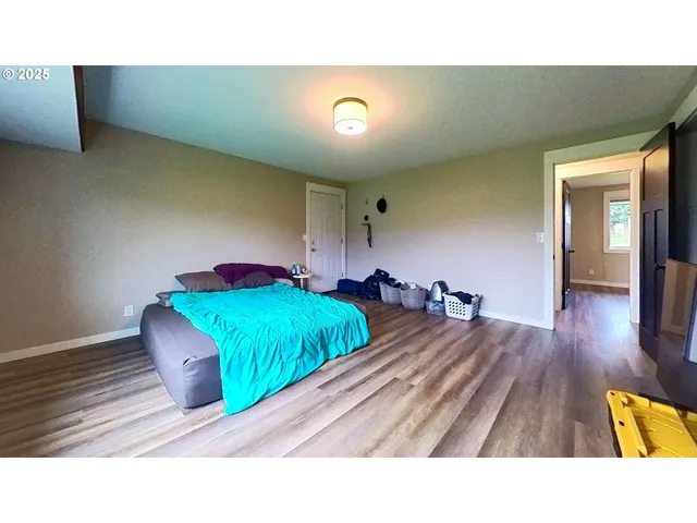 a living room with a bed furniture and a wooden floor