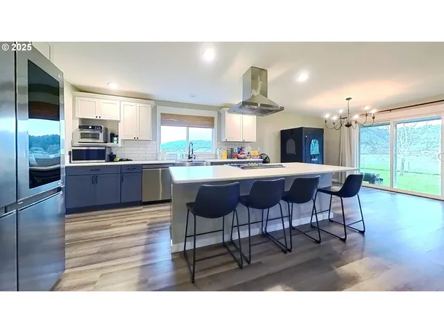 a kitchen with a sink and chairs