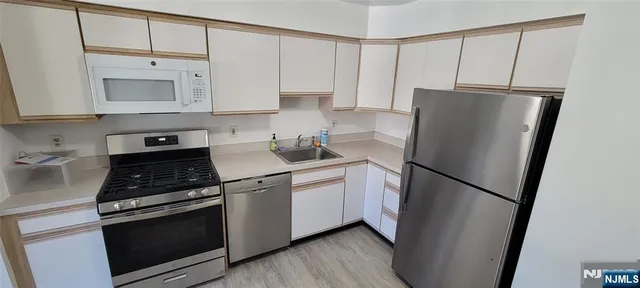 a kitchen with a refrigerator sink and cabinets