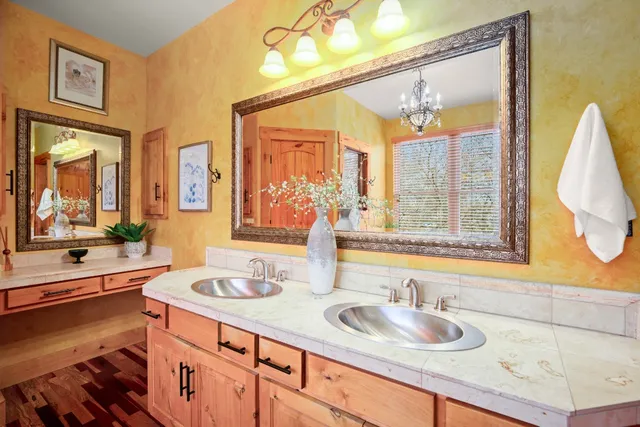 a bathroom with a granite countertop sink and a large mirror