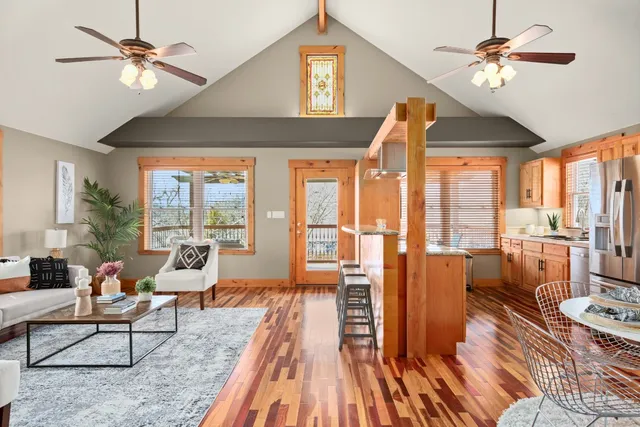 a living room with furniture a ceiling fan with a large window