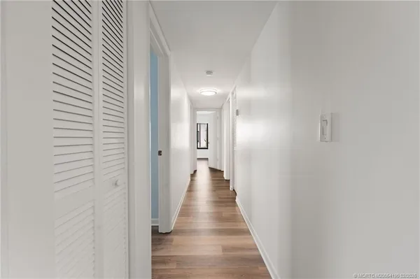 a view of a hallway with wooden floor