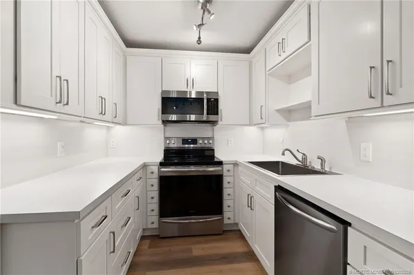 a kitchen with stainless steel appliances granite countertop a sink stove a refrigerator and cabinets