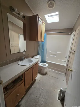 a bathroom with a granite countertop sink toilet and a mirror