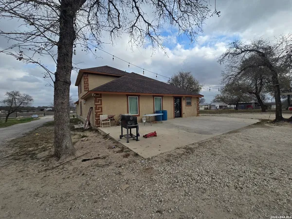 a white house covered with tall trees