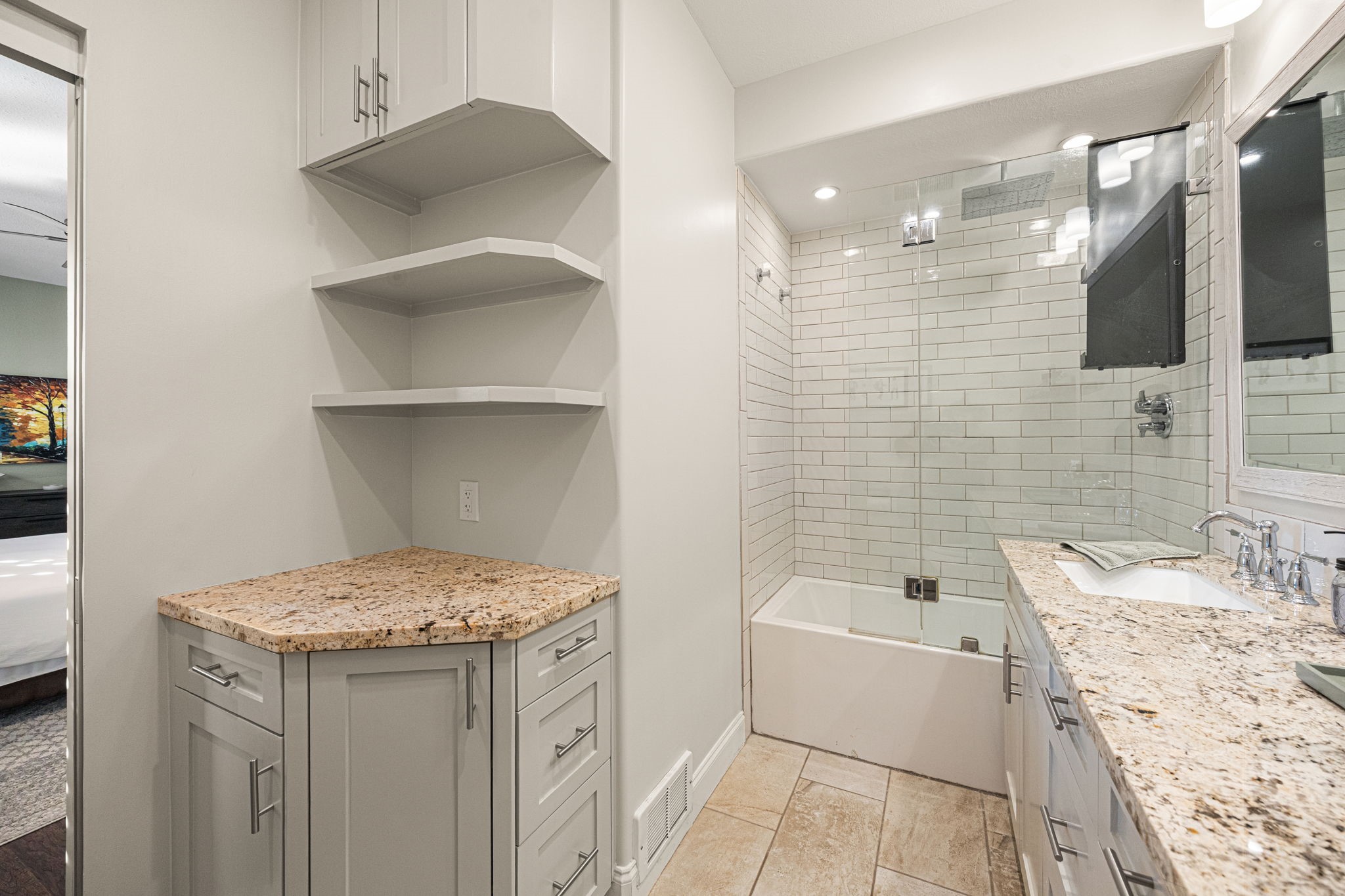 202 East 7th Street Houston, TX 77007 - Photo 19 of 27 Updated full bathroom featuring granite countertops, custom cabinetry, open shelving, and a glass-enclosed tub/shower combo.