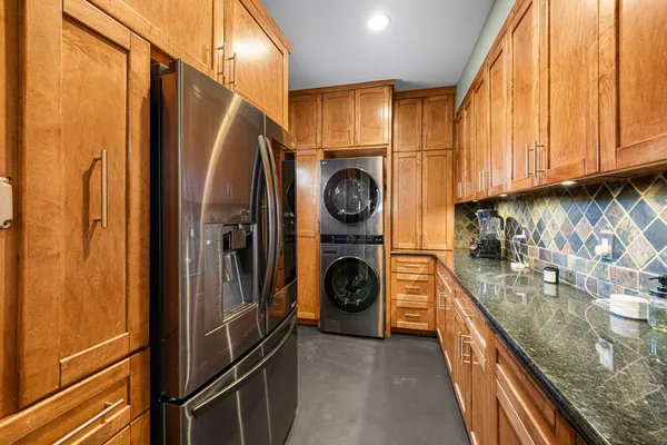 a kitchen with stainless steel appliances granite countertop a refrigerator a stove and a sink