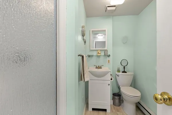 a white toilet sitting next to a bathroom sink and vanity