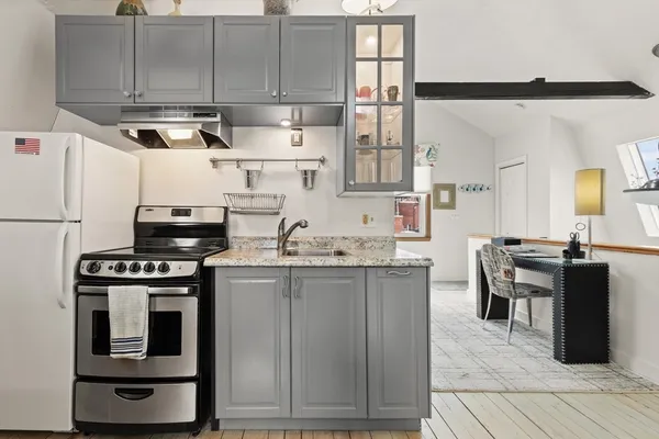 a kitchen with stainless steel appliances granite countertop a stove a sink and a refrigerator