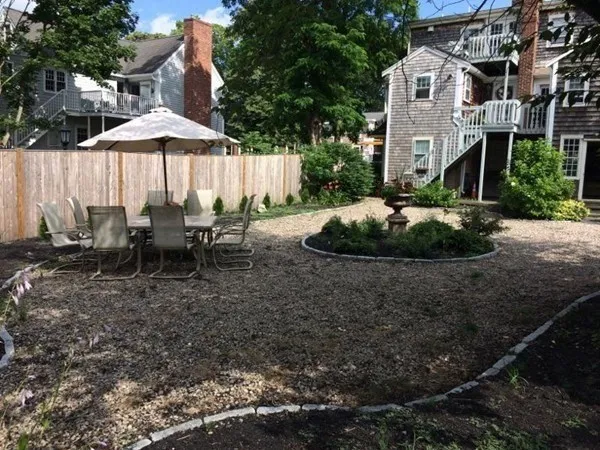 a view of a backyard with sitting area and tree