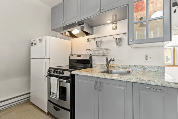 a kitchen with stainless steel appliances granite countertop a sink a stove and a refrigerator