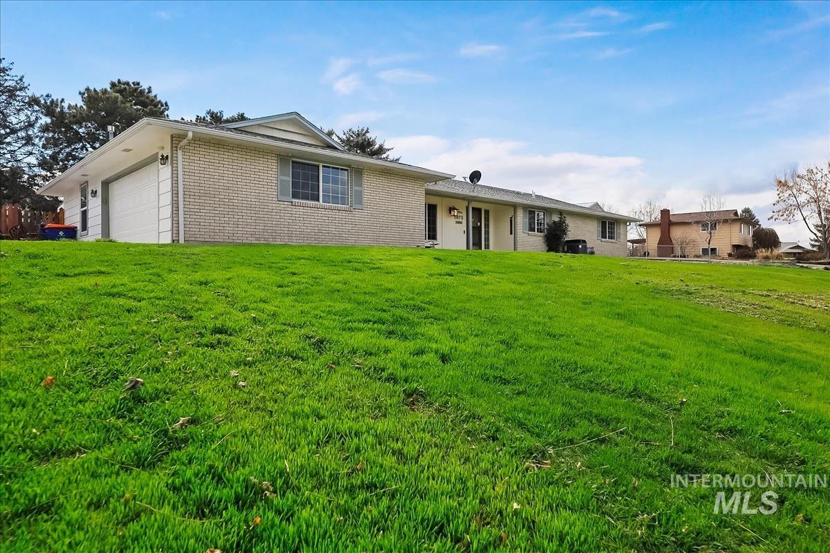 11875 West Hidden Valley Rim Road Boise, ID 83709 - Photo 2 of 36 Single story home featuring brick siding, a front yard, and a garage
