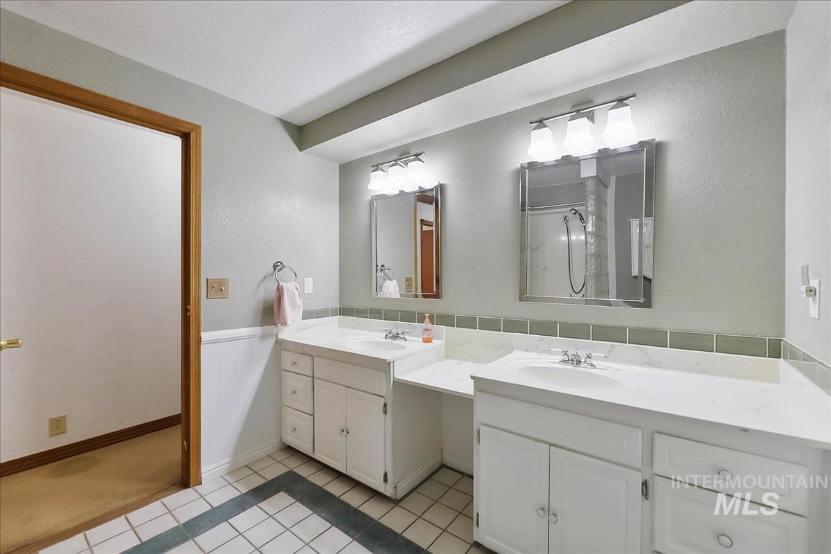 11875 West Hidden Valley Rim Road Boise, ID 83709 - Photo 22 of 36 Bathroom featuring a wainscoted wall, light tile patterned floors, and vanity