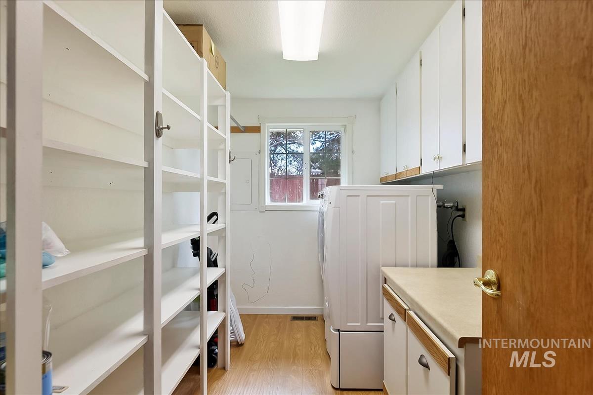 11875 West Hidden Valley Rim Road Boise, ID 83709 - Photo 26 of 36 Laundry area featuring cabinet space and light wood finished floors