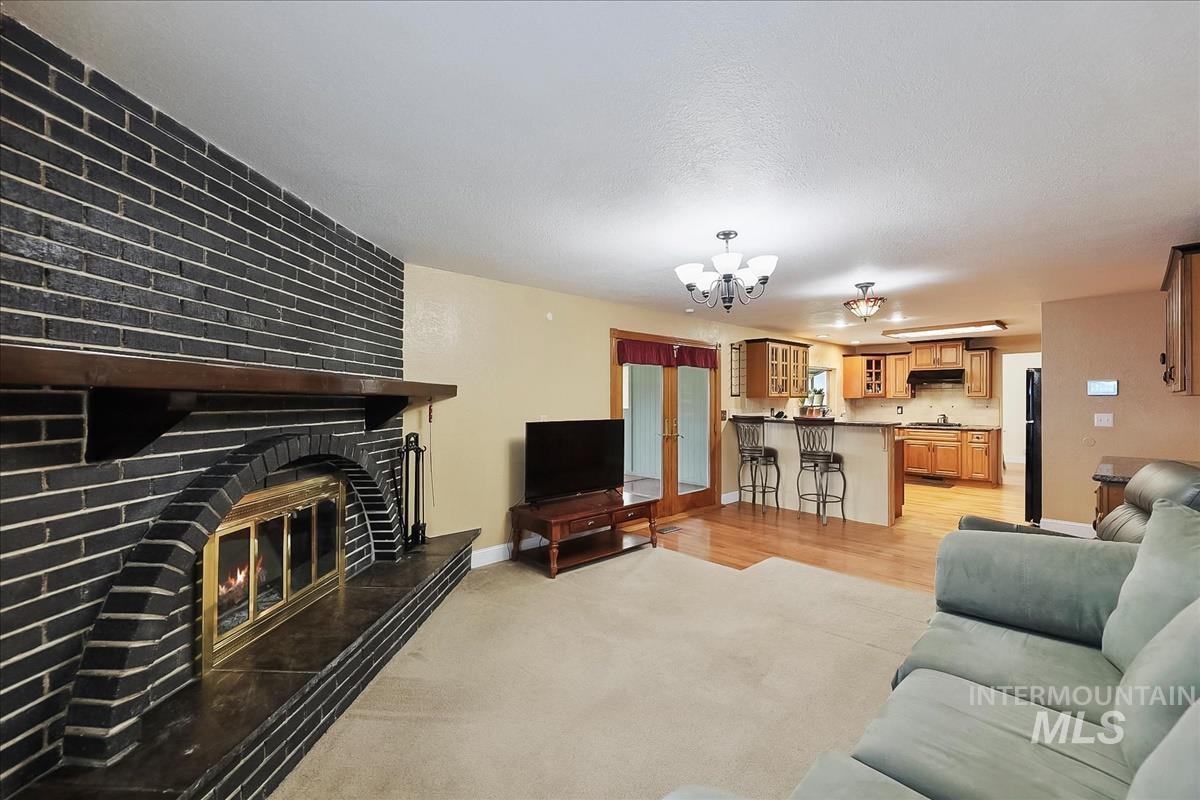 11875 West Hidden Valley Rim Road Boise, ID 83709 - Photo 3 of 36 Living room with suspended lighting, a large fireplace, and light carpet