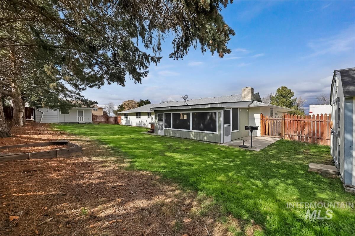 11875 West Hidden Valley Rim Road Boise, ID 83709 - Photo 31 of 36 Rear view of property featuring a chimney, a fenced backyard, and a sunroom