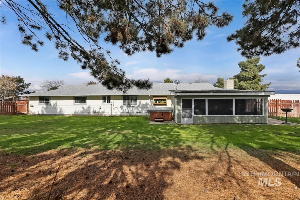 11875 West Hidden Valley Rim Road Boise, ID 83709 - Photo 32 of 36 Rear view of house featuring a hot tub, a chimney, and a sunroom